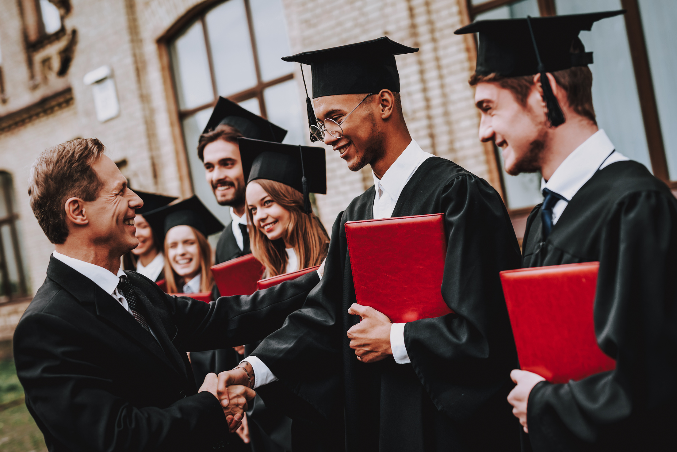 Teacher. Handshake. Students Diplomas. University.